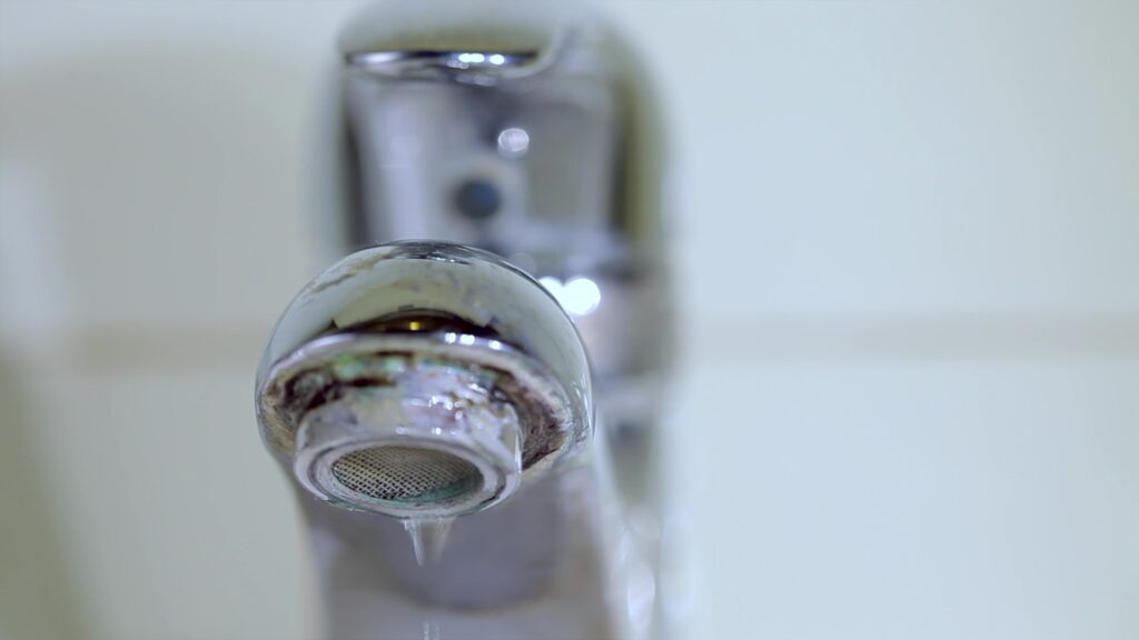 image of a sink tap with a water leak.